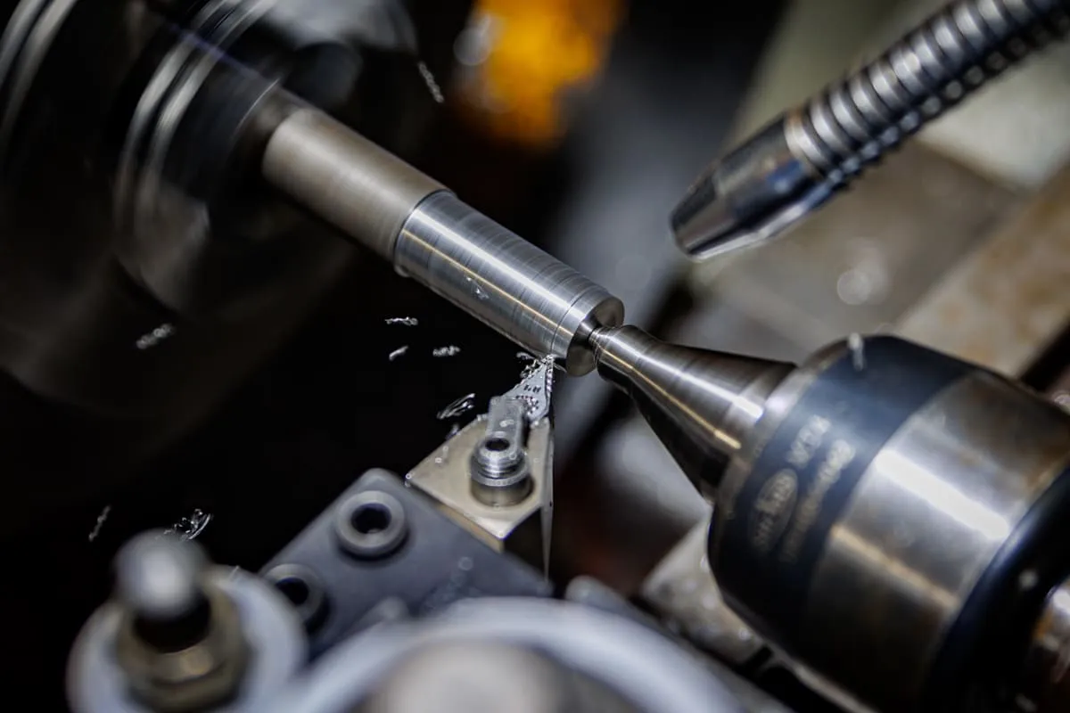 Close-up of a shaft being machined on a lathe